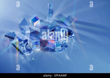 Prisms refracting light creating colorful spectrum on blue Stock Photo