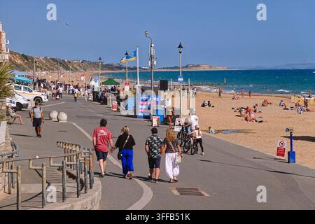 People walking along the Undercliff Drive promenade next to the sandy beach and sea at Boscombe Seafront in Bournemouth, UK. Stock Photo