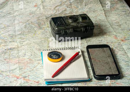 Wildlife trail camera and navigation tools on map Stock Photo