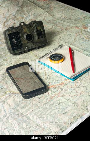 Planning wilderness exploration using trail camera, map, compass Stock Photo
