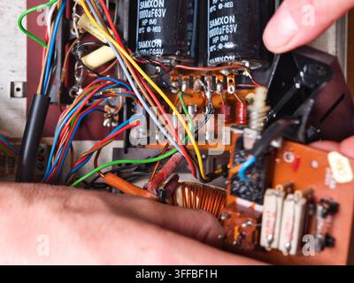 Electronic Circuit Board with Wires and - Close-up view of an intricate electronic circuit board with colorful wires, capacitors, and other components Stock Photo