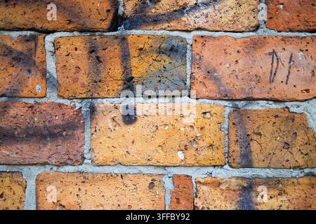 Old Weathered Orange Brick Wall Texture with Gray Mortar and Dark Stains Stock Photo