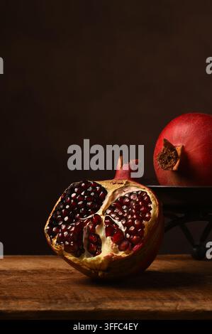 Pomegranate Still Life. Two ripe pomegranates one split open showing the seeds. Stock Photo