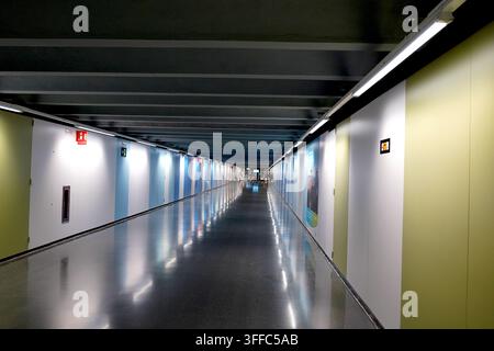 Bright underground pedestrian tunnel in Barcelona with colorful walls and a highly reflective polished floor Stock Photo