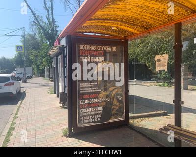 Bus stop with a military recruitment advertisement promoting contract army service in Russia, offering a one-time payment of 1.4 million rubles. Stock Photo