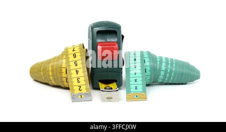A green measuring tape tool with yellow and teal tape measures extended on a white background, symbolizing accuracy and craftsmanship Stock Photo