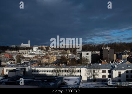 Panoramic view of Kaunas cityscape under a dark stormy sky, featuring St. Michael the Archangel Church and Christ's Resurrection Church. Stock Photo