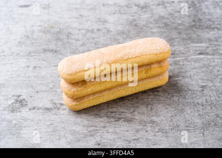Stacked Savoiardi biscuits on gray surface with generous copy space Stock Photo