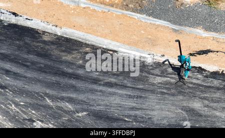 Overhead view of road curvimeter with measuring wheel positioned on fresh asphalt pavement at construction zone. Equipment used for precise distance m Stock Photo
