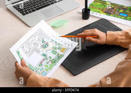 Landscape design and architecture planning, professional designer working on garden project with digital tablet and paper sketch at office desk Stock Photo