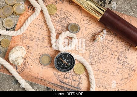 Compass, world map, seashells and rope on grey grunge background Stock Photo