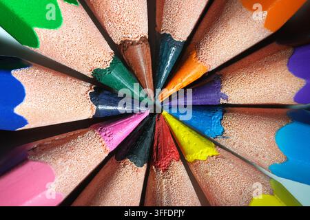 Crayon color pencils macro in centered arrangement. Colorful closeup of coloured pencils pointing at each other. Stock Photo