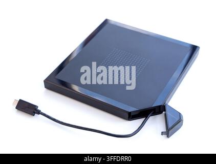 A black portable external optical drive with USBC cable sits on white Stock Photo