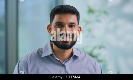 Portrait positive Indian Muslim businessman smiling looking at camera Arabian business man smile happy satisfied in office male executive agent Stock Photo