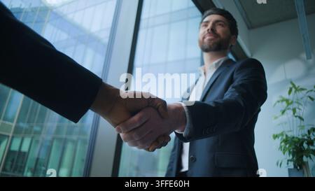 Two multiracial business men talk handshaking with work success banking Caucasian businessman shaking hands with unknown African man businessmen Stock Photo
