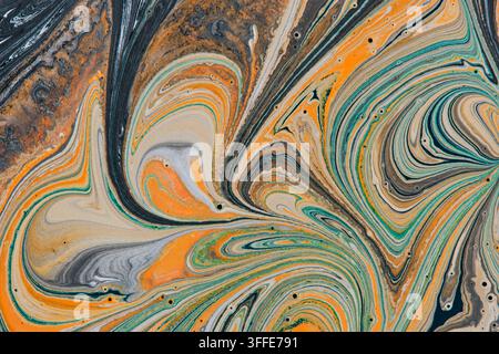 Abstract liquid paint mixing in swirl patterns orange turquoise cream and black colors macro Stock Photo