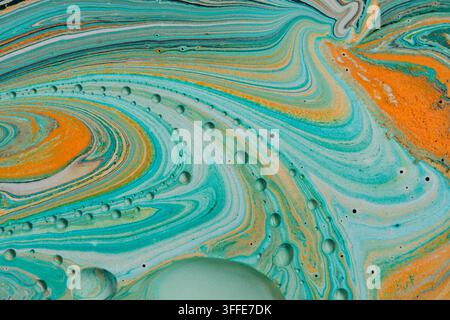 Soft turquoise and pastel orange fluid acrylic background with flowing curved lines and tiny droplets Stock Photo