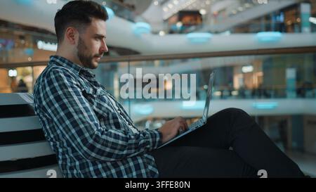 Calm serious Caucasian man freelancer student male working online with laptop in modern business center concentrated male guy using computer browsing Stock Photo