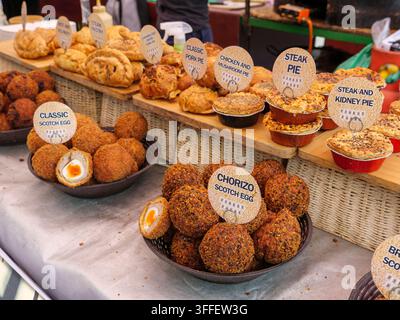 Scotch eggs and pies on sale at food stall on Broadway Market in Hackney, London, UK Stock Photo