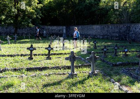 Historic Austro-Hungarian military cemetery with weathered stone grave markers of World War I soldiers among autumn trees in Brje pri Komnu. Stock Photo