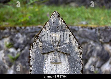 Historic Austro-Hungarian military cemetery with weathered stone grave markers of World War I soldiers among autumn trees in Brje pri Komnu. Stock Photo
