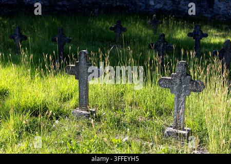 Historic Austro-Hungarian military cemetery with weathered stone grave markers of World War I soldiers among autumn trees in Brje pri Komnu. Stock Photo