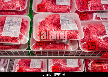 Packages of 85% lean ground beef on display in supermarket grocery store refrigerator case. Prices of ground beef have been rising. Stock Photo