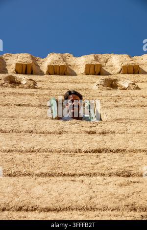 Man looking out from a window of a traditional mud house, Najran Province, Hubuna, Saudi Arabia Stock Photo