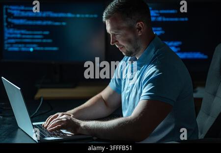 Network security specialist uses laptop. Network security specialist monitors cyber attack. Network security specialist analyzes code screen. Network Stock Photo