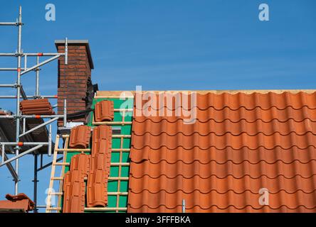 Roof under construction, installing clay roof tiles Stock Photo