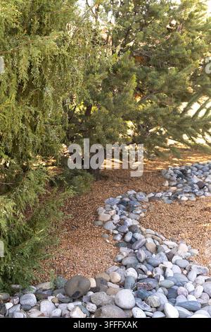 River Rock Creating a Dry Creek Bed in Garden Landscaping Stock Photo