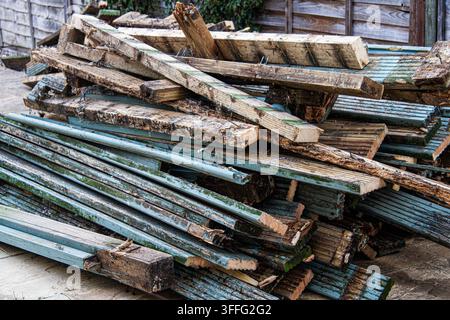 Image of a stack of used and discarded wooden posts and panels in a domestic garden setting with copy space Stock Photo