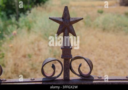 All that is left of an abandoned historic building in Van Horn, Texas is its two-story facade and an antique wrought iron fence with lone stars on it. Stock Photo