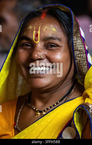 Smiling Indian woman wearing a yellow sari and traditional forehead marking in New Delhi, Stock Photo