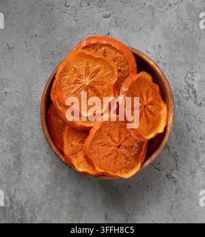 Dried orange slices in wooden bowl on stone Stock Photo