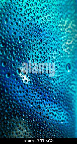 Water Droplets on Metal - Macro Photography  Close-up macro photograph showcasing a shimmering, blue-tinted metallic surface densely covered in water Stock Photo
