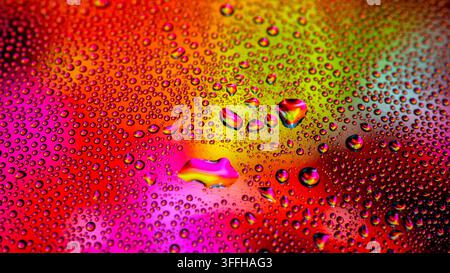 Colorful Water Droplets - Macro Photography  A stunning macro photograph featuring countless vibrant, multicolored water droplets suspended on a dark, Stock Photo