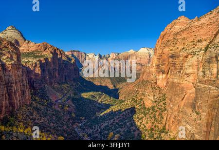 View of Pine Creek Canyon in Zion National Park,Utah, showing red rock cliffs and valley landscape under clear skies. Stock Photo