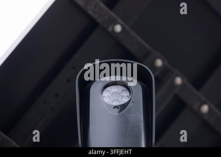 Cloudy daytime view of an AI artificial intelligence camera and solar panel on a pole. Stock Photo