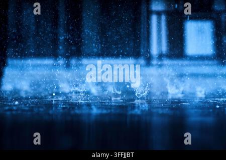 heavy raining make many small splash crown from water droplets drop down to the concrete floor in blue tone color scene Stock Photo