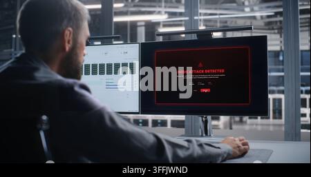 Network Operations Engineer Responds to DDoS Attack Across Data Center Infrastructure, Analyzing System Activity on Dual Monitors to Support Threat Mi Stock Photo