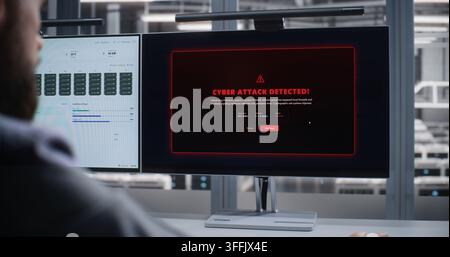 Cybersecurity Specialist Monitors Data Center After Cyber Attack Alert, Analyzing Dashboards on Dual Screens While Responding to Threats, Protecting Servers, Networks, and Digital Systems Securely. Stock Photo
