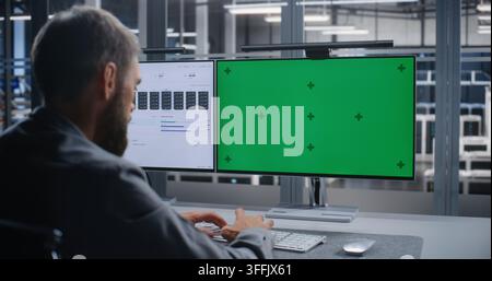 Male IT Specialist Working at Dual Monitor Workstation in Modern Server Facility, Reviewing Customizable Interface While Managing Digital Infrastructure, System Diagnostics, and Enterprise IT. Stock Photo