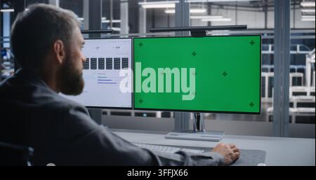 Male IT Specialist Working at Dual Monitor Workstation in Modern Server Facility, Reviewing Customizable Interface While Managing Digital Infrastructure, System Diagnostics, and Enterprise IT. Stock Photo