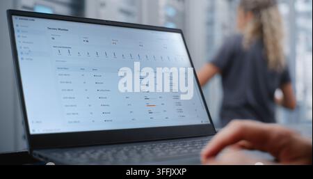 Male Network Engineer Monitors Server Telemetry as Critical Overheating Warning Appears, Analyzing System Metrics and Network Traffic While Responding to Infrastructure Performance Incident. Stock Photo