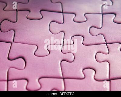 Purple jigsaw puzzle with last missing piece being placed into hole Stock Photo