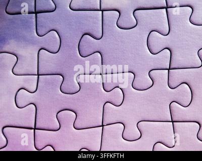 Purple jigsaw puzzle with last missing piece being placed into hole Stock Photo