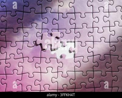 Purple jigsaw puzzle background with single missing element being inserted Stock Photo
