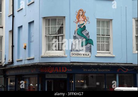 Urban tourism and local culture, mermaid mural painted on a blue building facade at Dicken s Walk. Historic town center architecture with traditional Stock Photo