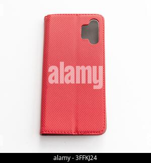 A red textured phone wallet case lies on a white surface Stock Photo